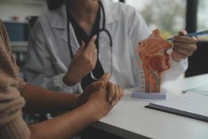 fêmea médico explicando para paciente resultados do modelo a processo do pacientes. diagnóstico do doenças para modelo interno órgão. foto