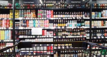 abstrato borrado imagem do álcool loja com carrinho dentro departamento loja. foto