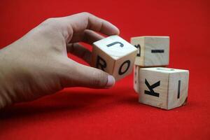 uma mão segurando educacional empilhamento cubo brinquedo fez do madeira com números e cartas foto