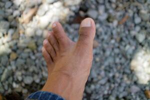 uma homem pernas dentro Sombrio Castanho. ásia cara. cascalho fundo foto