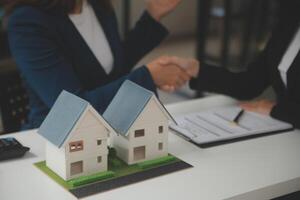 o negócio assinatura uma contrato Comprar - vender casa, seguro agente analisando sobre casa investimento empréstimo real Estado conceito. foto