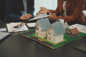 equipe do arquiteturas e empresários discutindo e debate em chão plano modificação para real Estado investimento e habitação desenvolvimento projeto foto