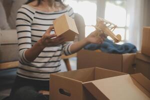 dois ásia blogueiro mostrando roupas dentro frente do a Câmera para gravação vlog viver transmissão às dela fazer compras. conectados compras carrinho noção. em sofá às casa foto