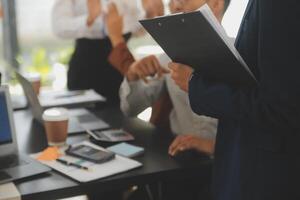 o negócio equipe encontro trabalhando com Novo comece projeto, discussão e análise dados a gráficos e gráficos. digital tábua, calculadora, computador portátil computador usando, o negócio finança e contabilidade conceito. foto