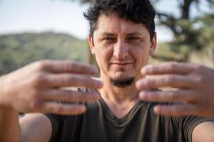 caucasiano homem práticas árvore abraçando pose, uma chave chi kung técnica. fechar-se tomada. foto