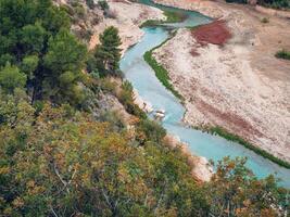 panorama do uma rio fluindo dentro uma montanhoso área dentro floresta em uma nublado dia, aéreo Visão foto