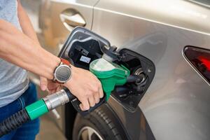 fechar acima Visão do motorista mão preenche acima caro Gasolina dentro self-service o preenchimento estação dentro Europa. Alto qualidade foto