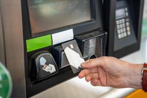 fechar acima Visão do homem mão paga para combustível com uma crédito cartão em terminal do self-service o preenchimento estação dentro Europa. Alto qualidade foto