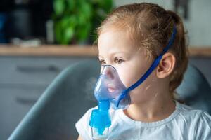 fofa pequeno menina estão sentado e segurando uma nebulizador mascarar inclinado contra a face, via aérea tratamento conceito. Alto qualidade foto