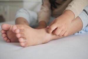 uma criança sofrimento a partir de comichão pele em pés foto