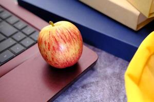 costas para escola conceito com maçã e escola saco em mesa foto