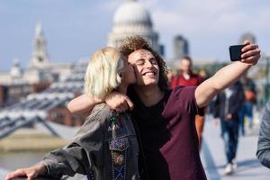 casal feliz tirando uma foto de selfie na ponte do milênio em Londres