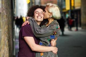 jovem casal abraçando no meio urbano em uma típica rua de Londres.