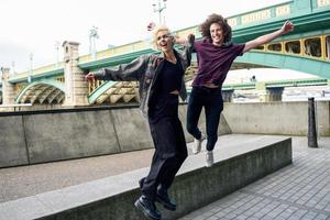 casal engraçado junping perto da ponte Southwark sobre o rio Tamisa, em Londres foto
