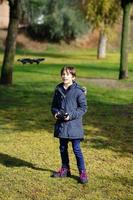 menina de nove anos operando drone de brinquedo voando por controle remoto foto