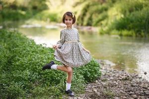 menina no riacho da natureza com um lindo vestido foto