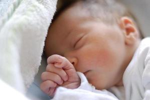 bebê recém-nascida na cama do hospital hospedeiro dormindo foto