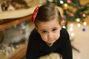 menina em casa com decoração e luzes de natal desfocadas foto