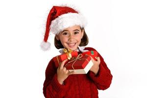 menina com chapéu de Papai Noel carregando muitas caixas de presente