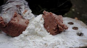 um jovem chef está fazendo massa de recheio de hambúrguer na beira de uma cachoeira foto