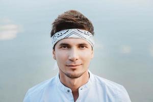 retrato de homem bonito em reflexo de água de fundo de céu azul foto