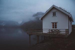 noruega rorbu casas e montanhas rochas sobre a paisagem do fiorde viagem escandinava ver as ilhas lofoten. paisagem noturna. foto