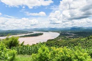 panorama da bela paisagem da Tailândia - vista em planta de montanha e flores amarelas com rio e fundo de céu azul foto
