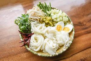 comida da tailândia macarrão de aletria ovos cozidos e vegetais frescos no prato servido na mesa de madeira - macarrão de arroz tailandês foto