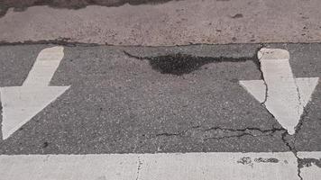 sinal de seta branca na estrada de asfalto foto