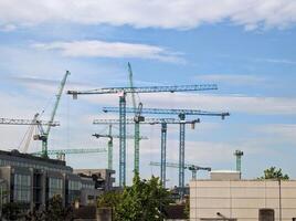 grande guindastes às construção local dentro Dublin, Irlanda, construção e construção máquinas fundo foto