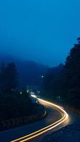 colorida noite luz trilhas em estrada com floresta fundo dentro punca bogor Indonésia foto