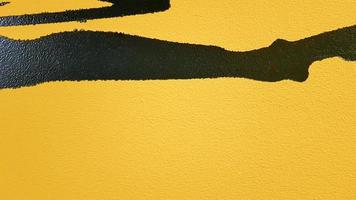 salpicos de tinta preta abstrata pingando sobre um fundo amarelo brilhante. salpicos de tinta preta sobre um fundo amarelo. conceito de idéias de arte. textura do pincel amarelo e preto no fundo foto