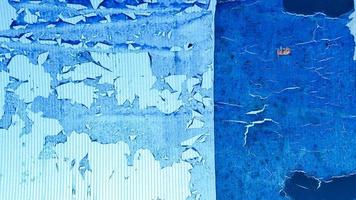 superfície ondulada de plástico irregular com restos de filme e papel escamoso. fundo azul obsoleto abstrato. cópia espaço, design. textura ou fundo de parede com tinta azul grão foto
