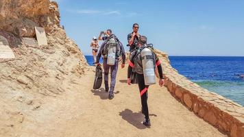 egito, sharm el sheikh - 10 de junho de 2019. mergulhadores com equipamento de mergulho vão para o mar pelo céu com nuvens em egypt dahab. um buraco azul a leste do Sinai, na costa do Mar Vermelho. foto