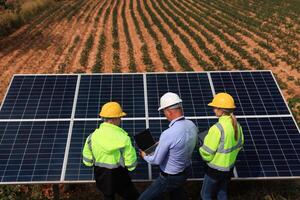 a Engenharia desenhador teve uma discussão com dele trabalho em equipe às solar painéis sobre a protótipo do a solar célula às a campo foto