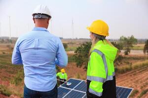 homem de negocios ou proprietário Verifica trabalho progresso do solar painel instalação, sustentável e renovável energia, o negócio discussão foto