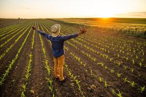 africano agricultor é em pé dentro dele crescendo trigo campo. ele é satisfeito com progresso do plantas. foto