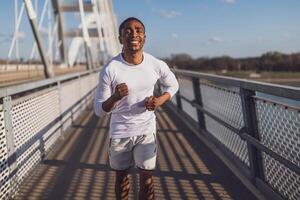 jovem afro-americano homem é corrida em a ponte dentro a cidade. foto