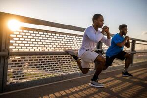 dois afro-americano amigos estão exercício em a ponte dentro a cidade. elas estão fazendo agachamentos. foto