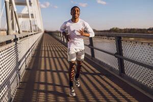 jovem afro-americano homem é corrida em a ponte dentro a cidade. foto