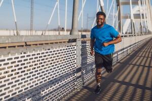 jovem afro-americano homem é corrida em a ponte dentro a cidade. foto