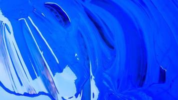 fundo abstrato de tinta azul derramada com baldes em um fundo preto. tinta azul está derramando sobre um fundo preto. use-o para um artista ou conceito criativo. tintas derramadas sobre fundo azul foto