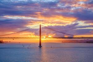 Visão do 25 de abril ponte sobre tagus rio em pôr do sol. Lisboa, Portugal foto