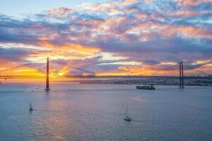 Visão do 25 de abril ponte sobre tagus rio em pôr do sol. Lisboa, Portugal foto