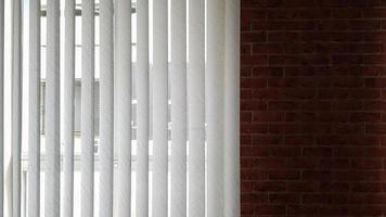 cortinas são colocadas na janela para proteger do calor e da luz solar em ambientes fechados. as venezianas da casa captam a luz do sol. foto