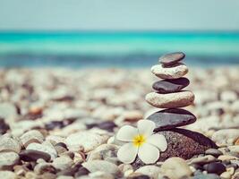 zen equilibrado pedras pilha com plumeria flor foto