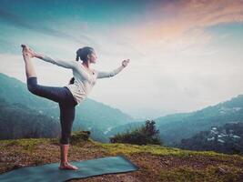 mulher fazendo ioga asana natarajasana ao ar livre às cascata foto