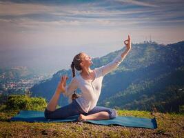 sorte em forma mulher fazendo ioga asana ao ar livre dentro montanhas foto