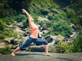 mulher fazendo Ashtanga Vinyasa ioga asana virabhadrasana 1 Guerreiro foto