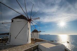 moinhos de vento gregos tradicionais na ilha de mykonos ao nascer do sol, cyclades, grécia foto